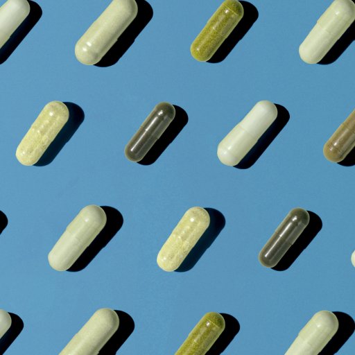 Various capsules arranged diagonally on a blue surface, alternating between light and dark colors.