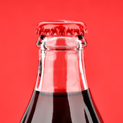 A bottle of Coca Cola on a red background.
