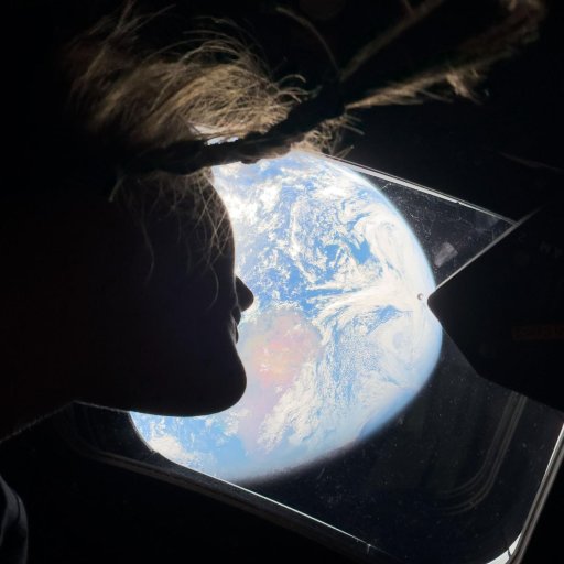 A person with hair floating upwards looks out of a spacecraft window at Earth, filled with hope as clouds and oceans shimmer below—a view reminiscent of the Artemis II mission’s journey.