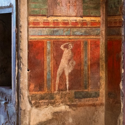 Ancient wall fresco depicting a standing human figure, surrounded by red, green, and brown decorative panels—an evocative remnant bearing the marks of history’s lost voices and the passage of time.